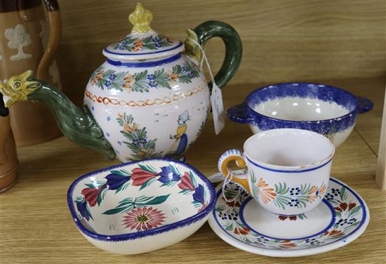 A Quimper teapot with dragon spout, a cup and saucer and two later bowls